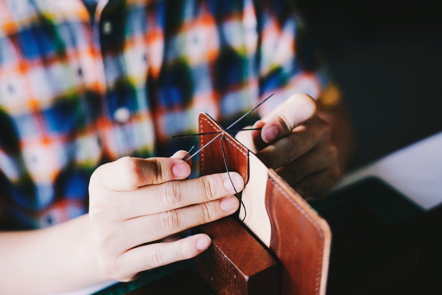 A person making a leather wallet