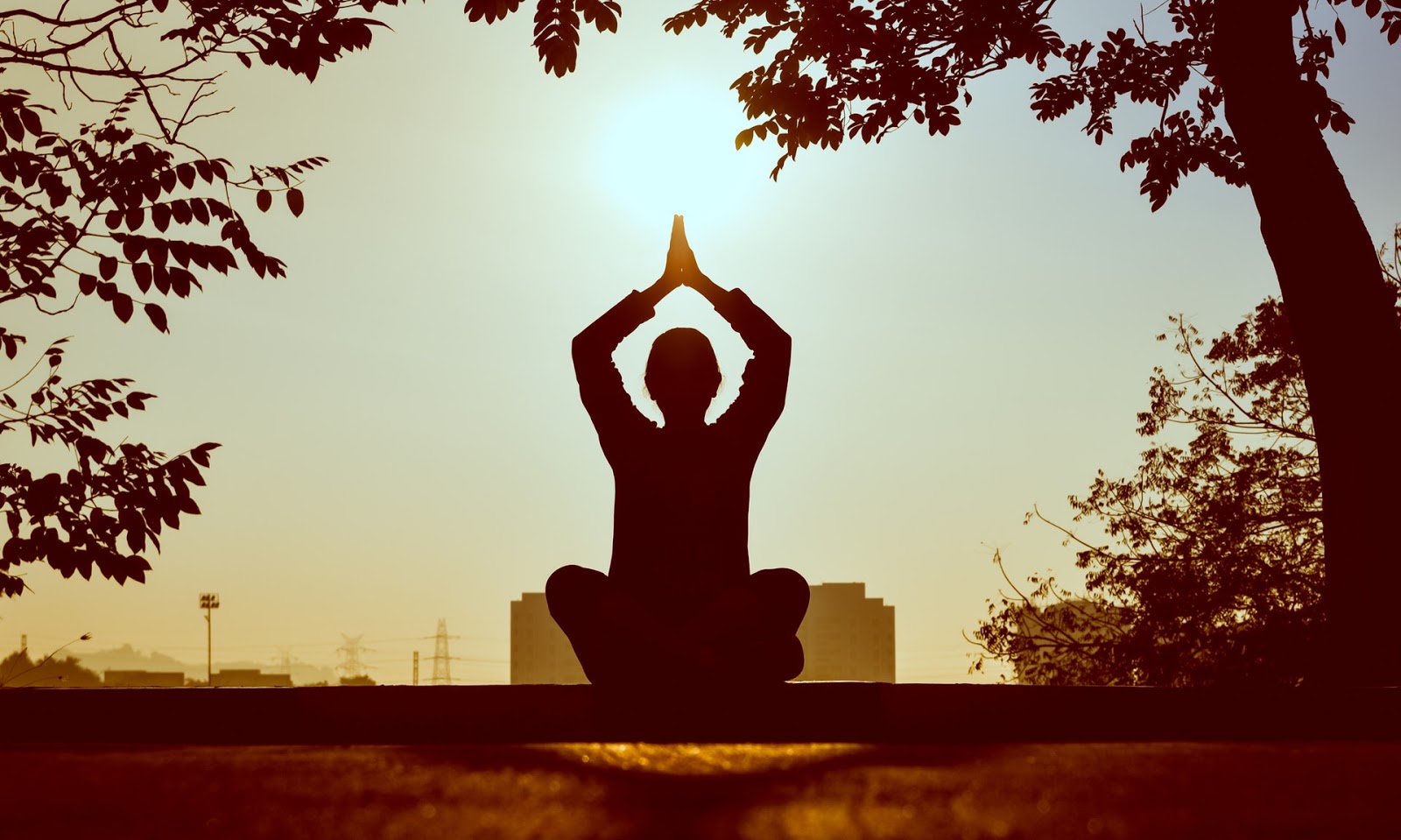 Woman meditating in view of a city