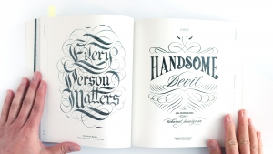 Victionary book open to a page showcasing intricate hand-lettered designs.