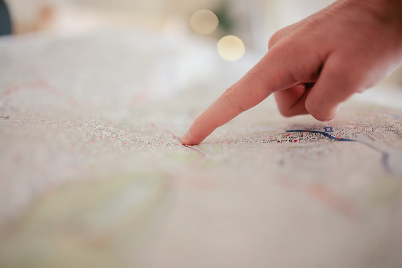 Person pointing to point on a map and finding direction.