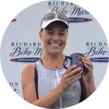 Rachel P. holding marathon trophy after being coached by Coach Bev