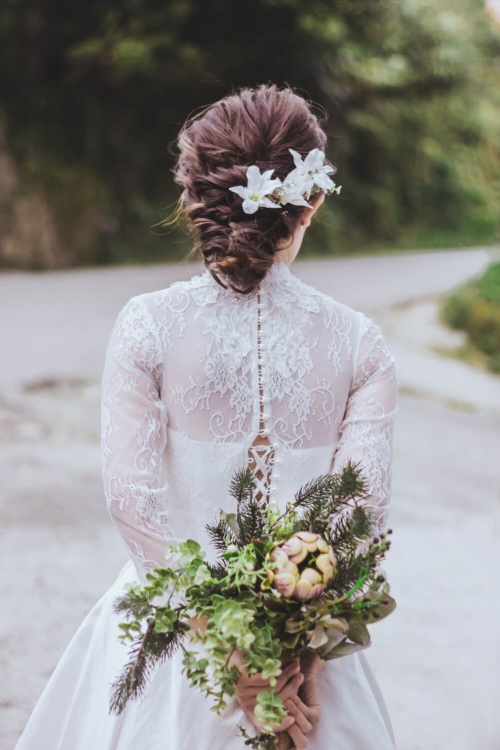 Woman holding wedding bouquet behind back