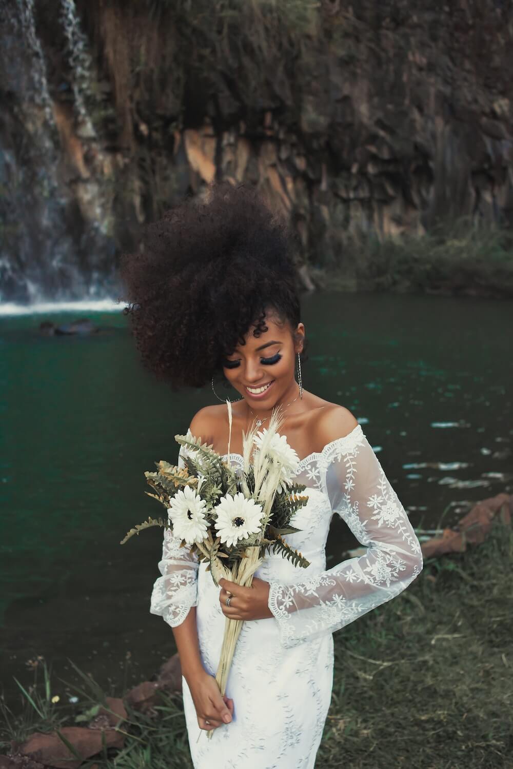 Woman standing near water holding bouquet