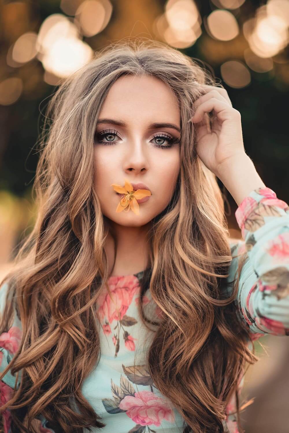 Woman with orange flower on her lips