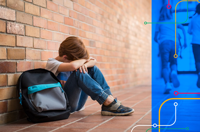 Criança vítima de bullying sentada no pátio da escola