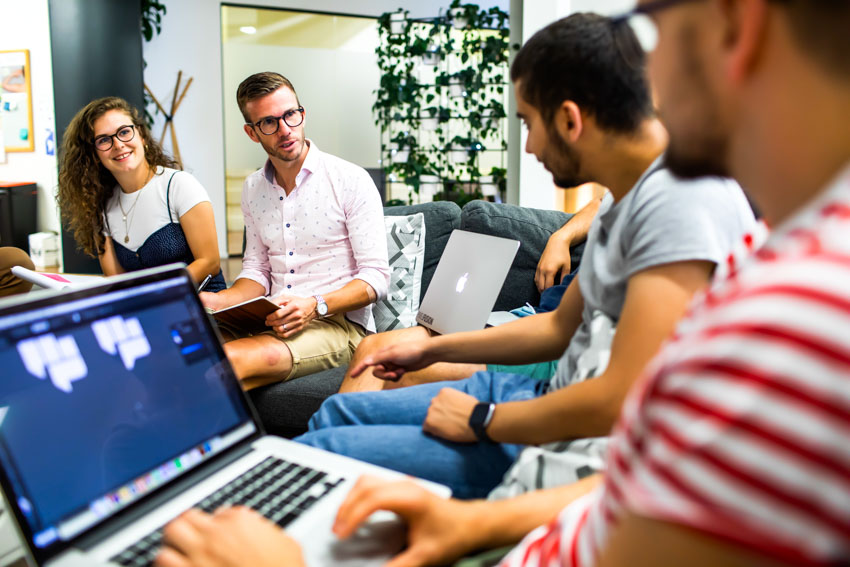 Man conducting sales training session with woman and two other men