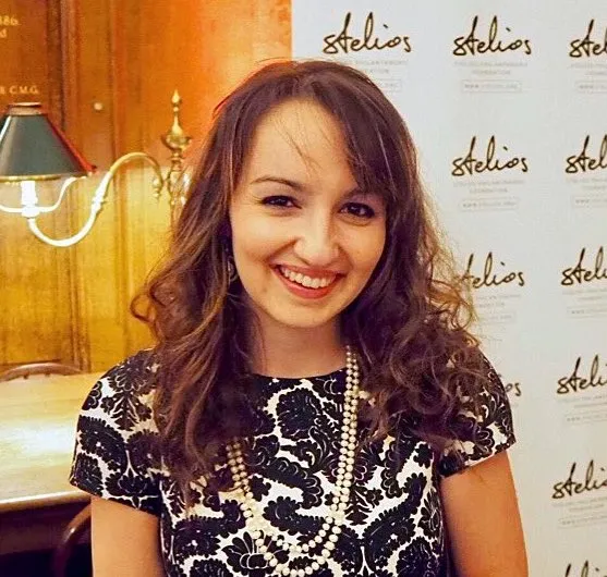 Beth smiling at the camera in smart dress.