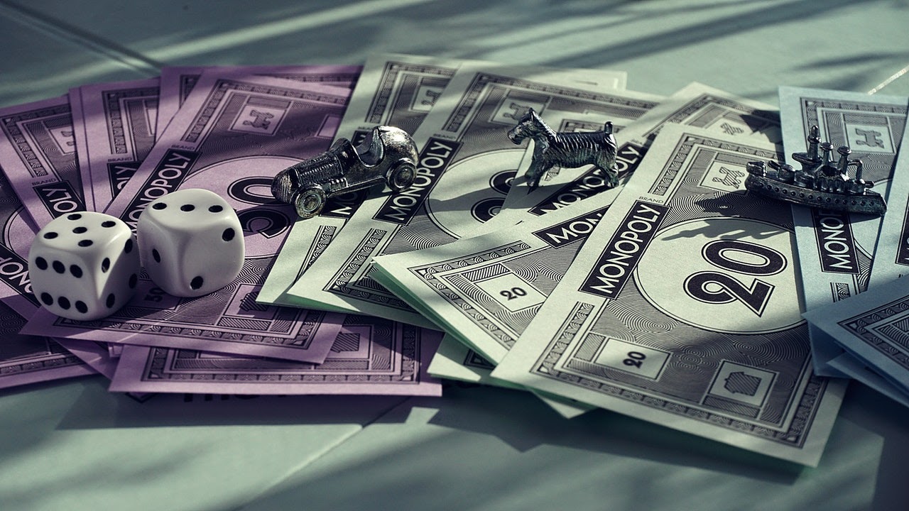 Monopoly money, dice, and playing tokens sit on a table.