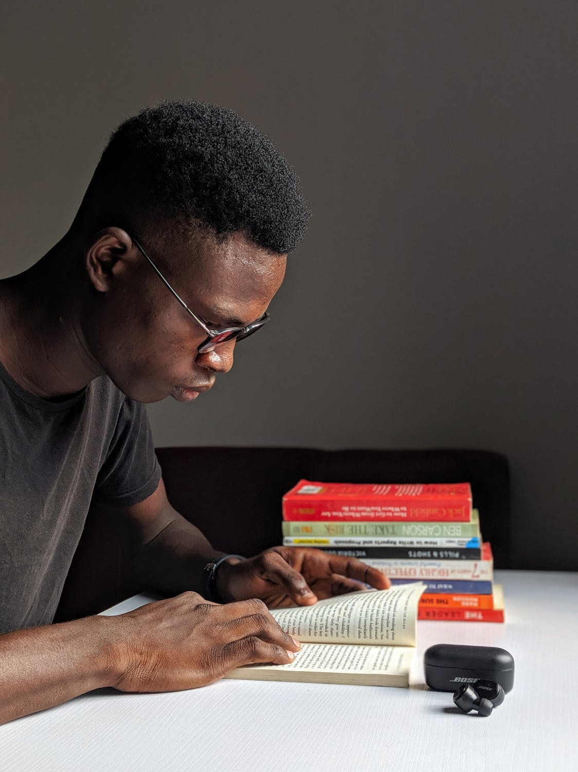 Male in his twenties reading a book at his desk