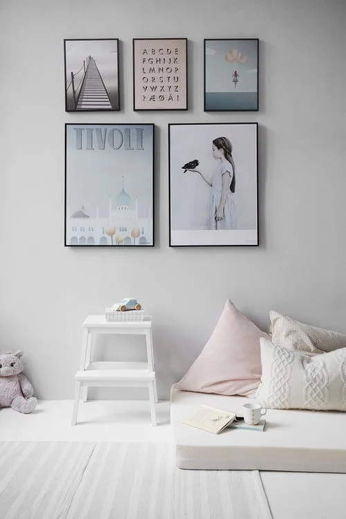 Art portraits on wall using consistent colors of blue, gray, and white