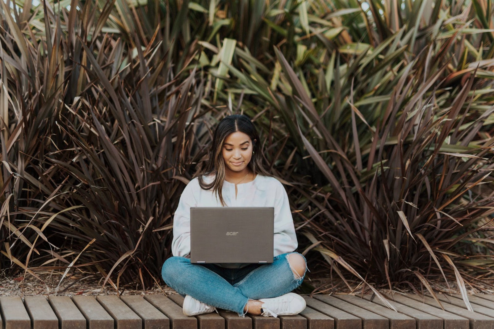 A girl outside on her laptop