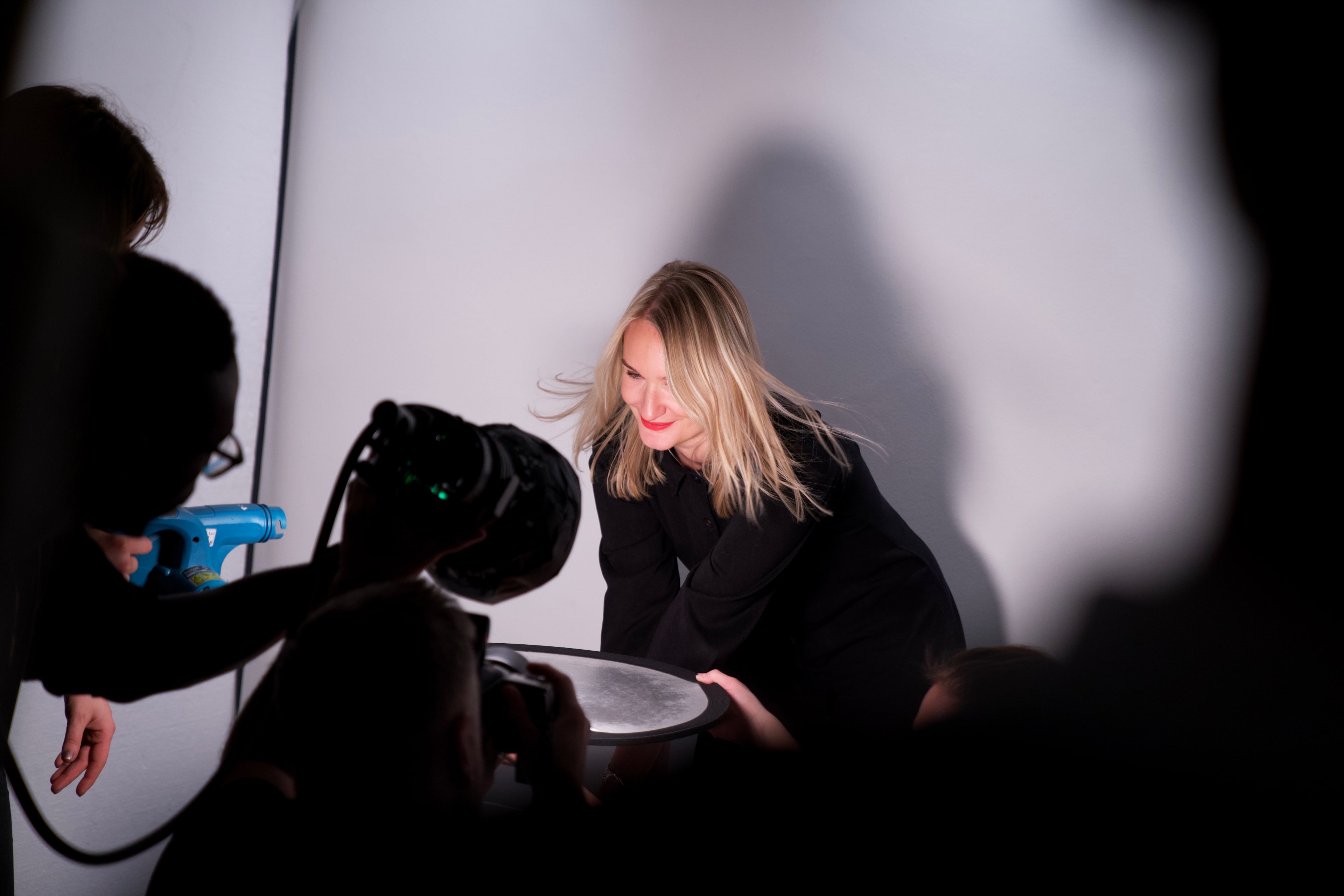 Woman being photographed against a white backdrop