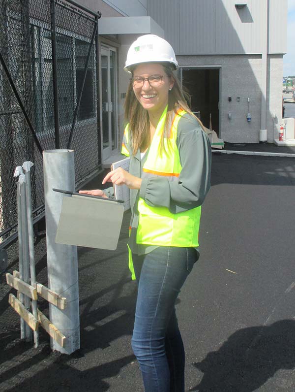 Cori on site wearing a hard hat and neon vest.