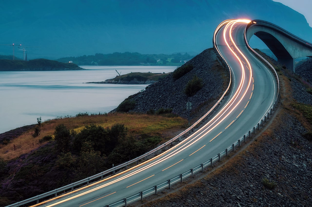Blurred light stretches along windy, mountainous road