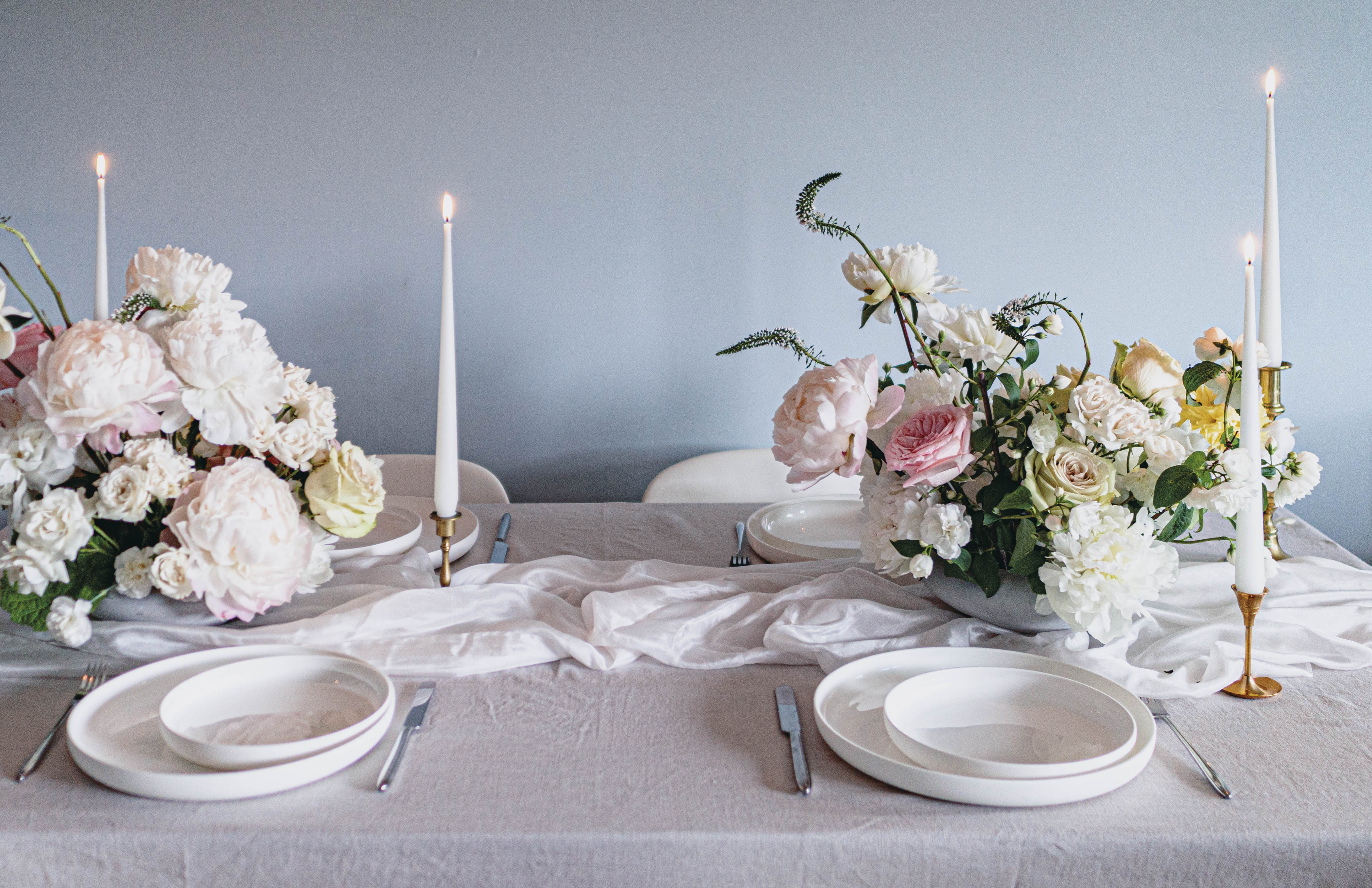Flower Symbolism: What does your wedding bouquet mean? 8 Peonies and Roses Wedding Table Centrepieces and Table Set-up with White Round Plates and Tapered Candles in Antique French Candlestick