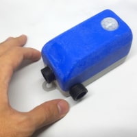 A photo of mini disinfectant pump early model showing the inlet and outlet and motion sensor