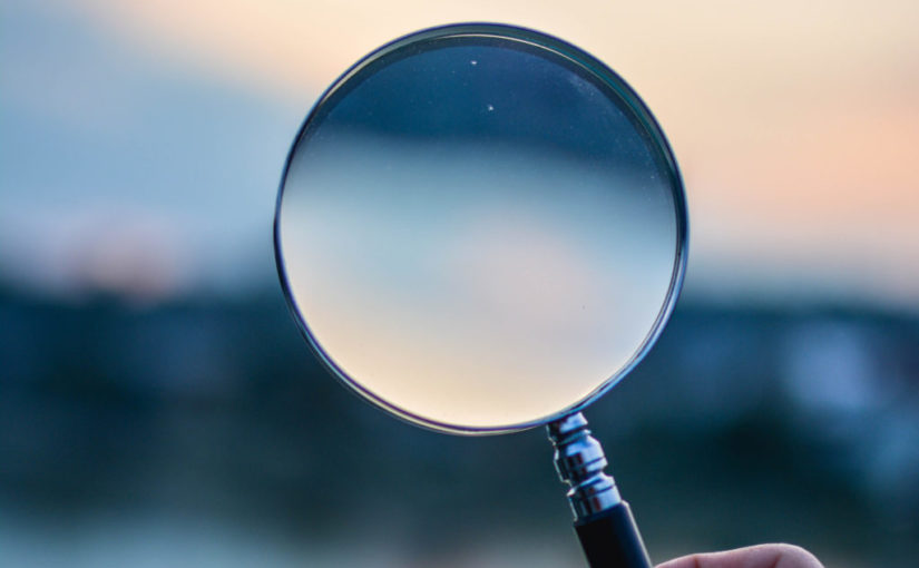 Magnifying lenses with a blurred skyline in background.