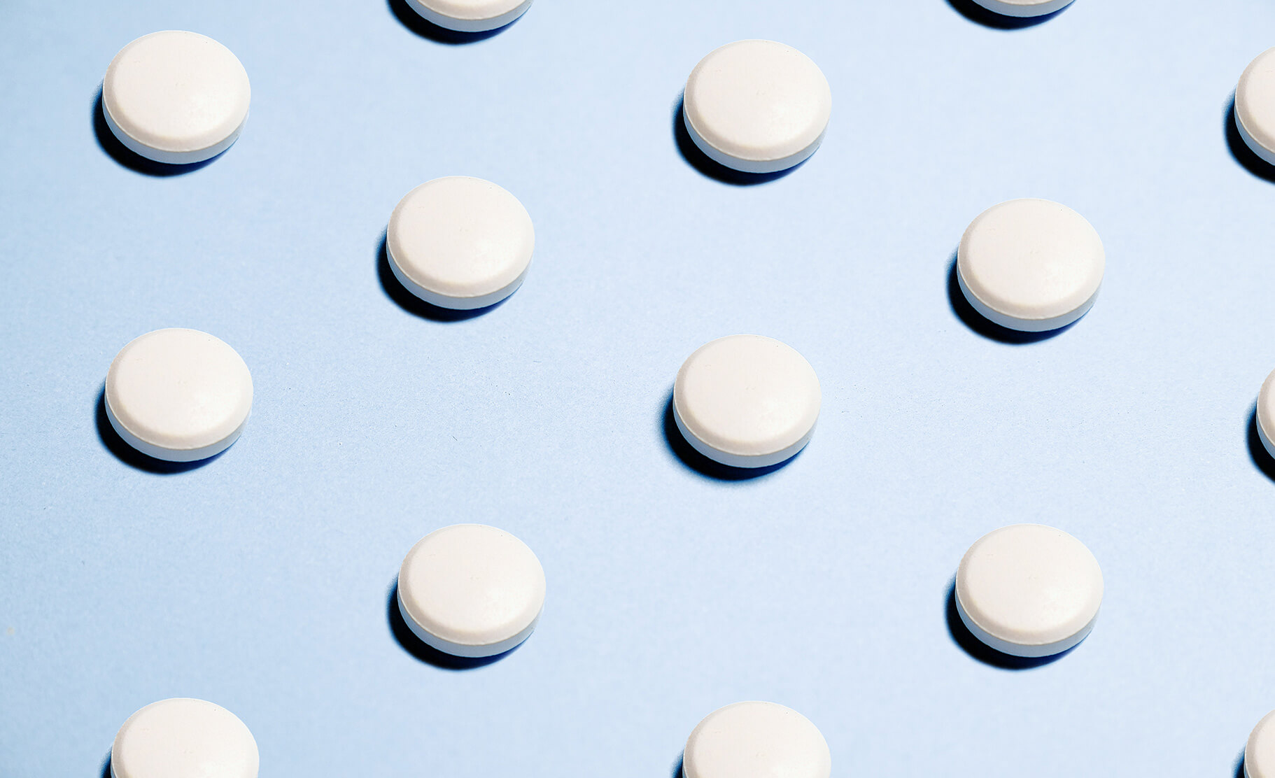 white ketamine-like tablet pills on a blue background