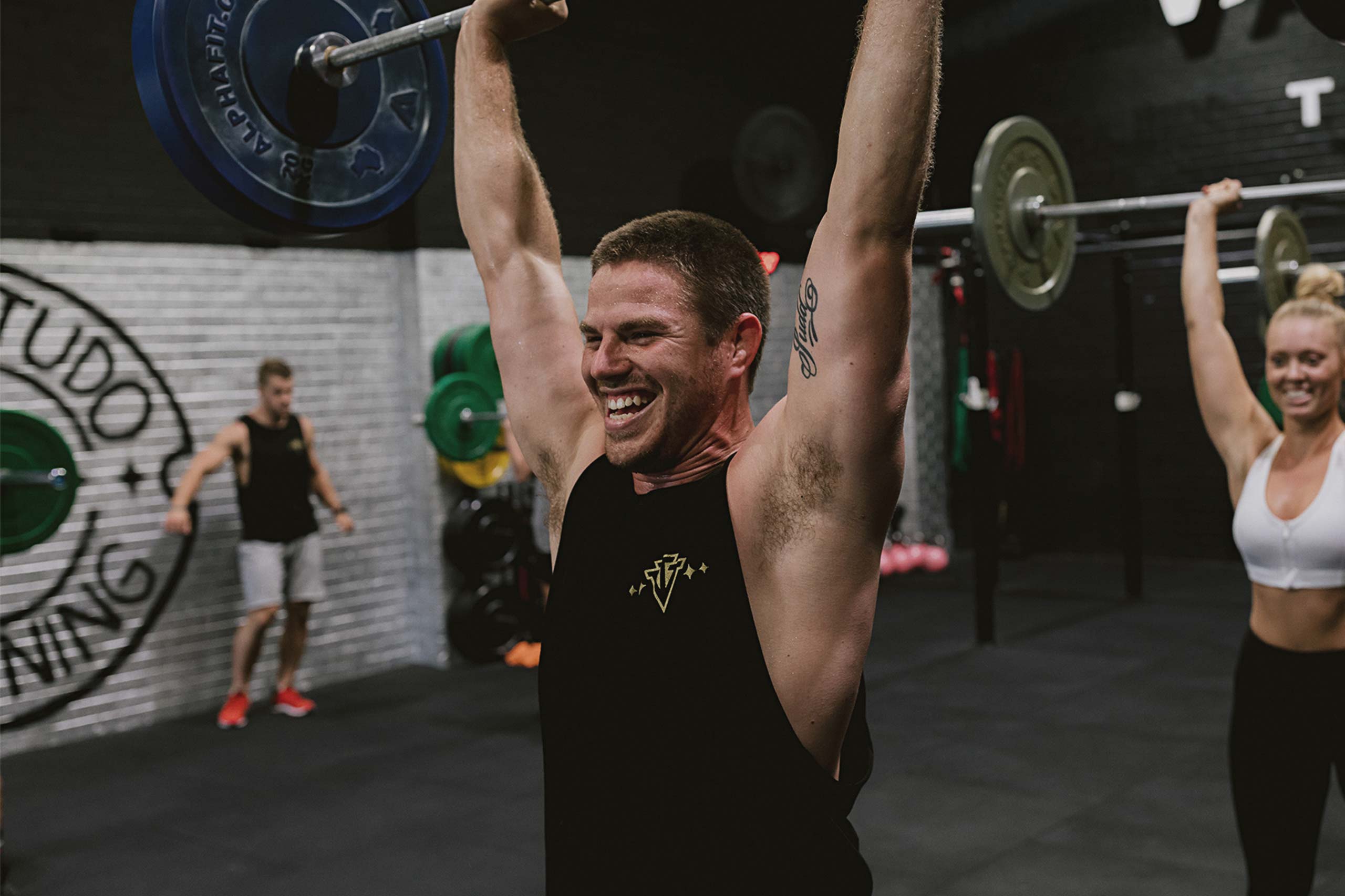 man lifting barbell weights over head