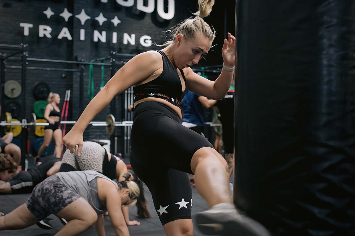 female athlete kicking punching bag