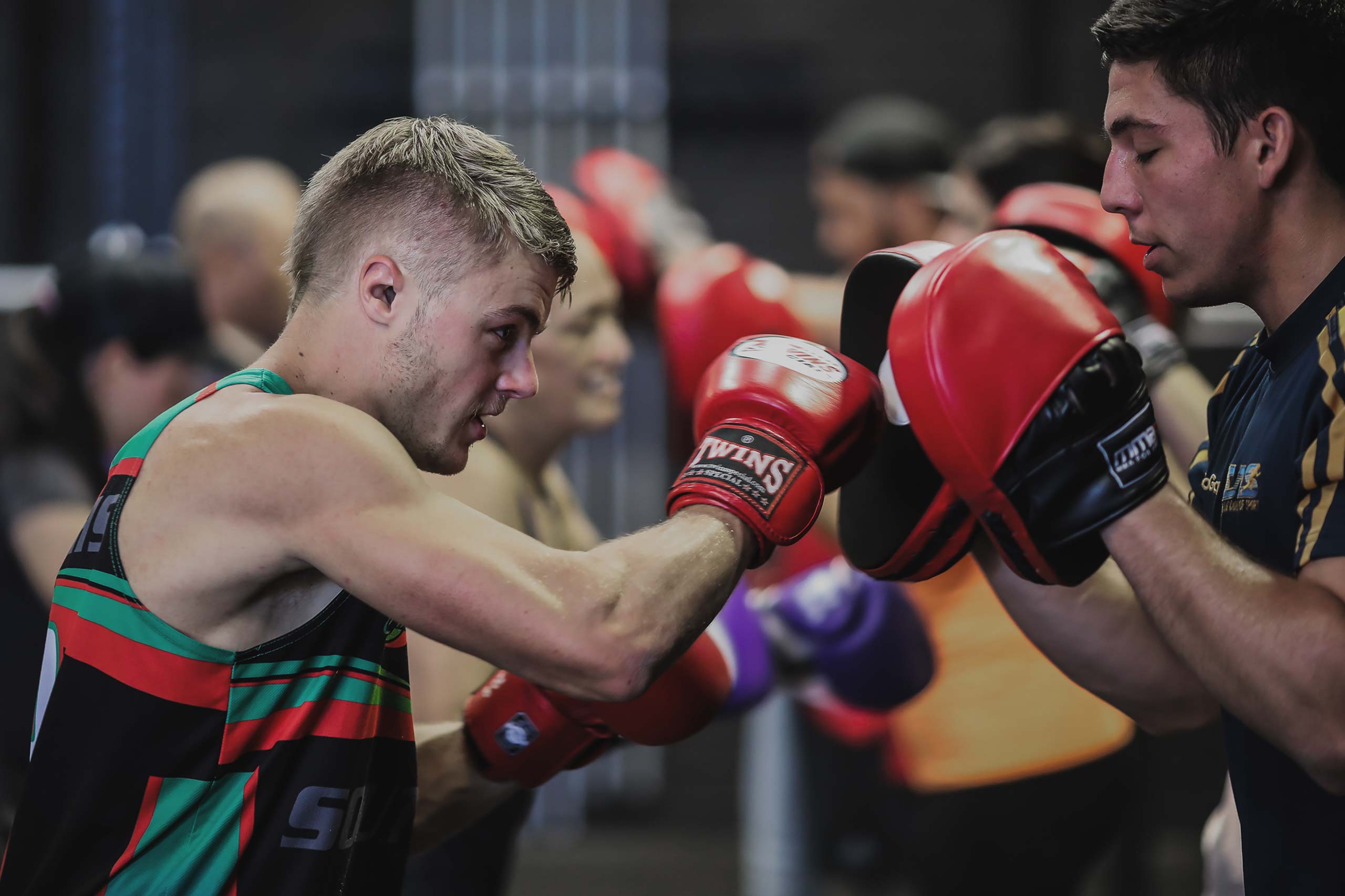 man punching boxing pads at vale tudo