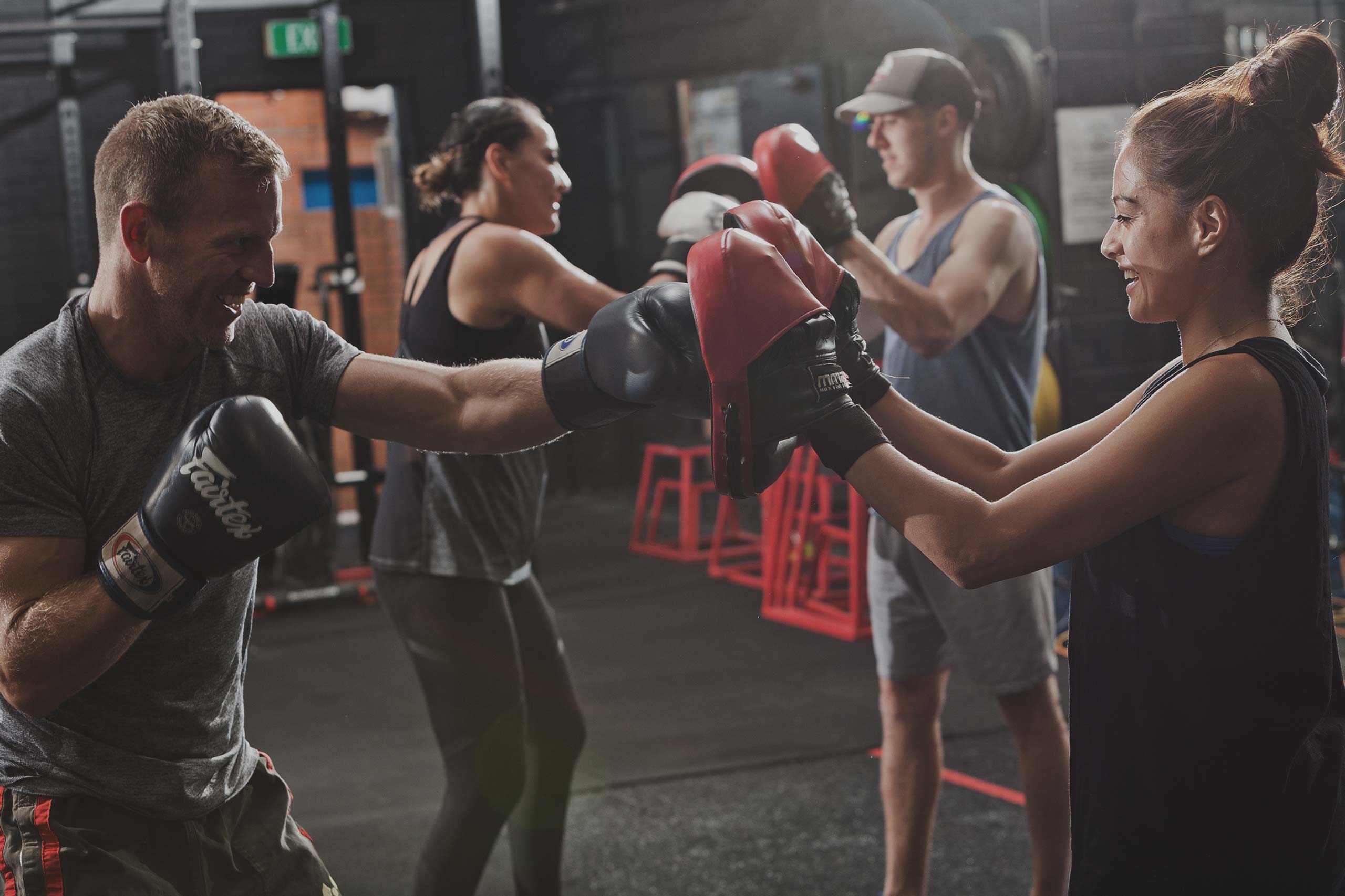 man and woman punching boxing pads at vale tudo