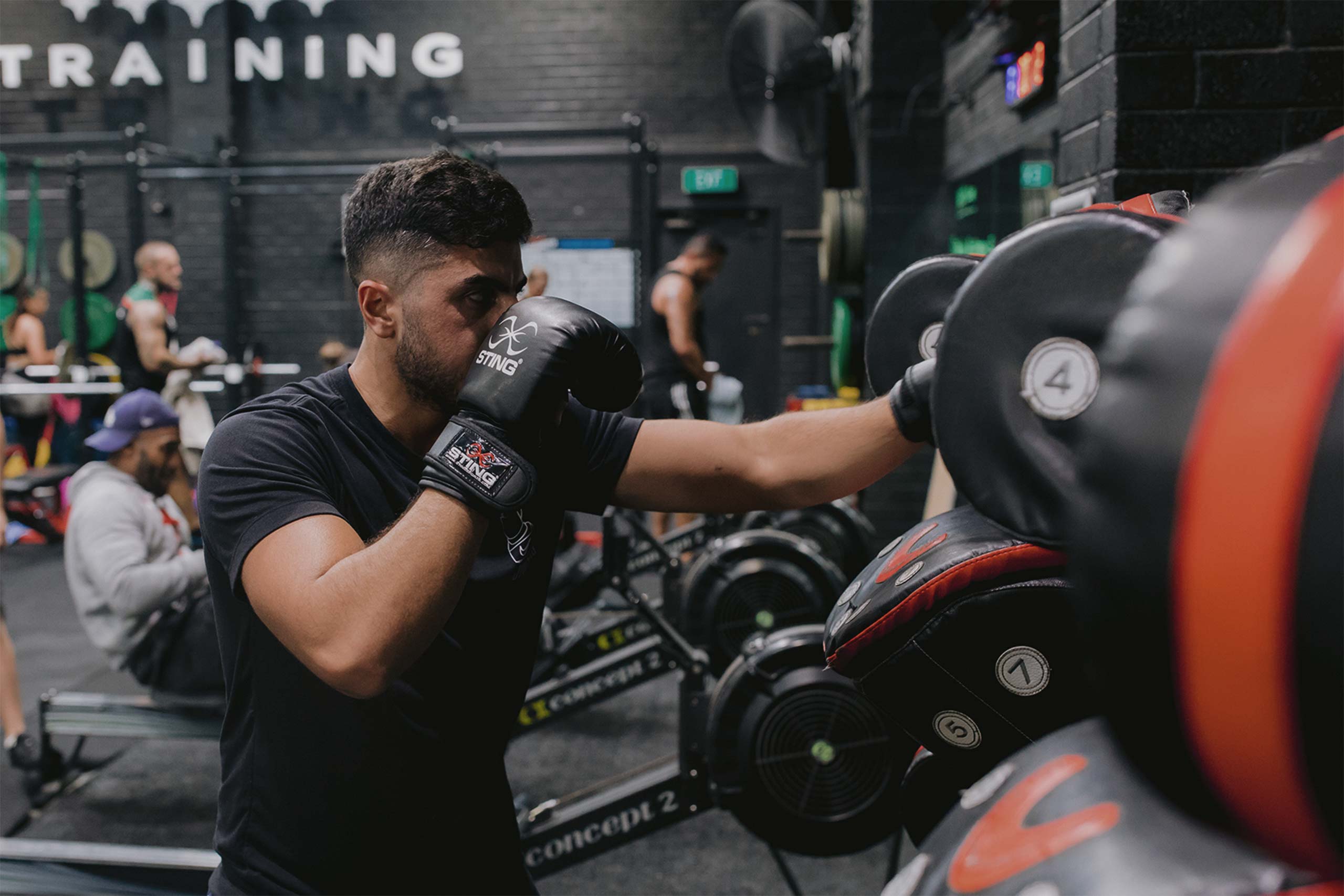 man and woman punching boxing pads at vale tudo