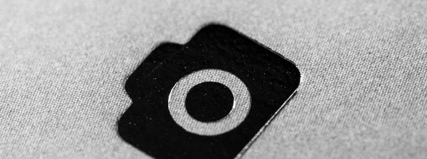 klein zwarte icon van een fotocamera op een stukje stof