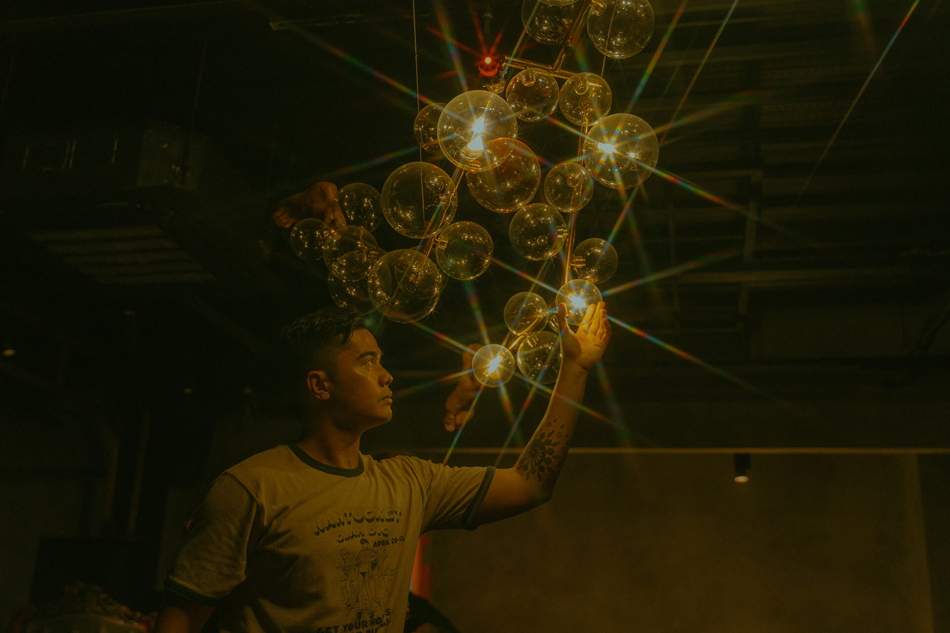 Visual artist Leeroy New adjusts an art fixture at KONDWI Art Space