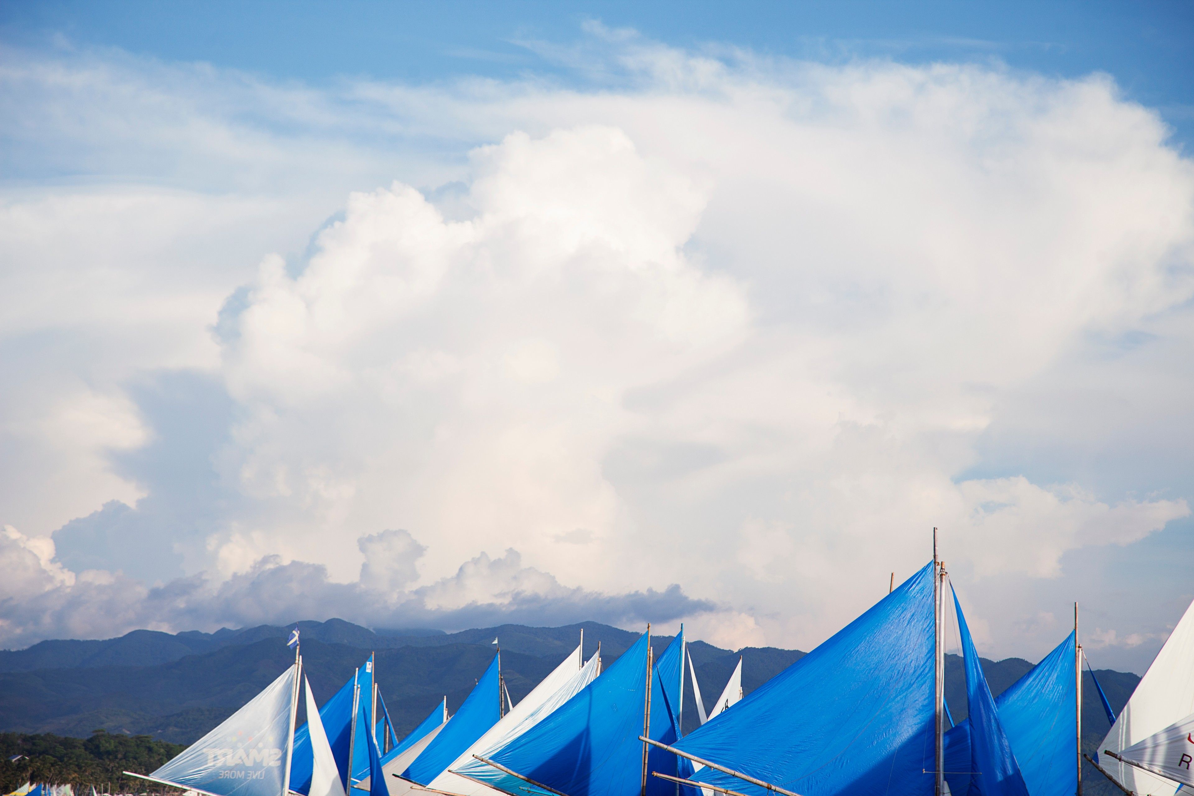 The sails of Boracay's iconic Paraws along the white sand beach