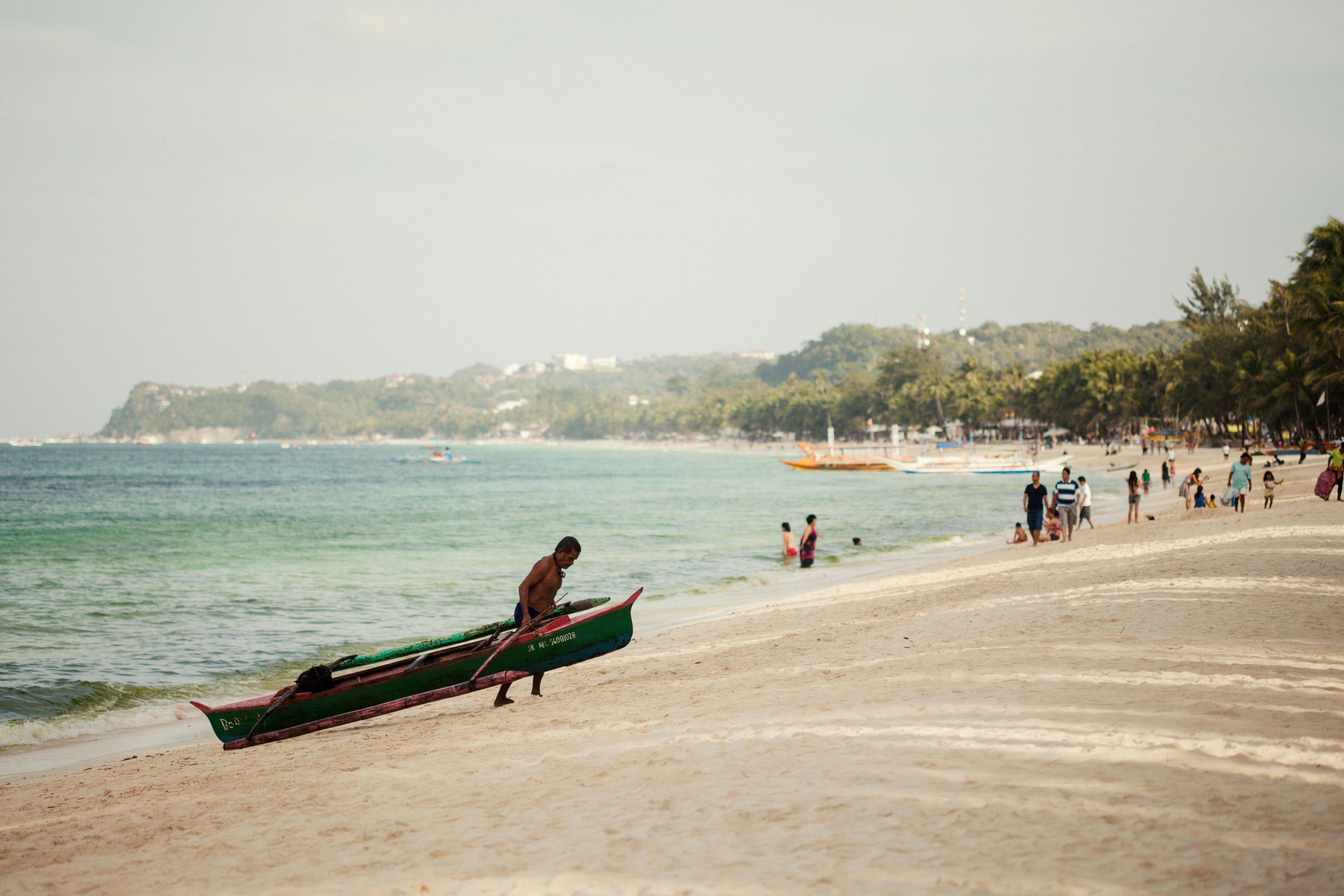 Photo of a Boracay local dragging his boat to the shore.
