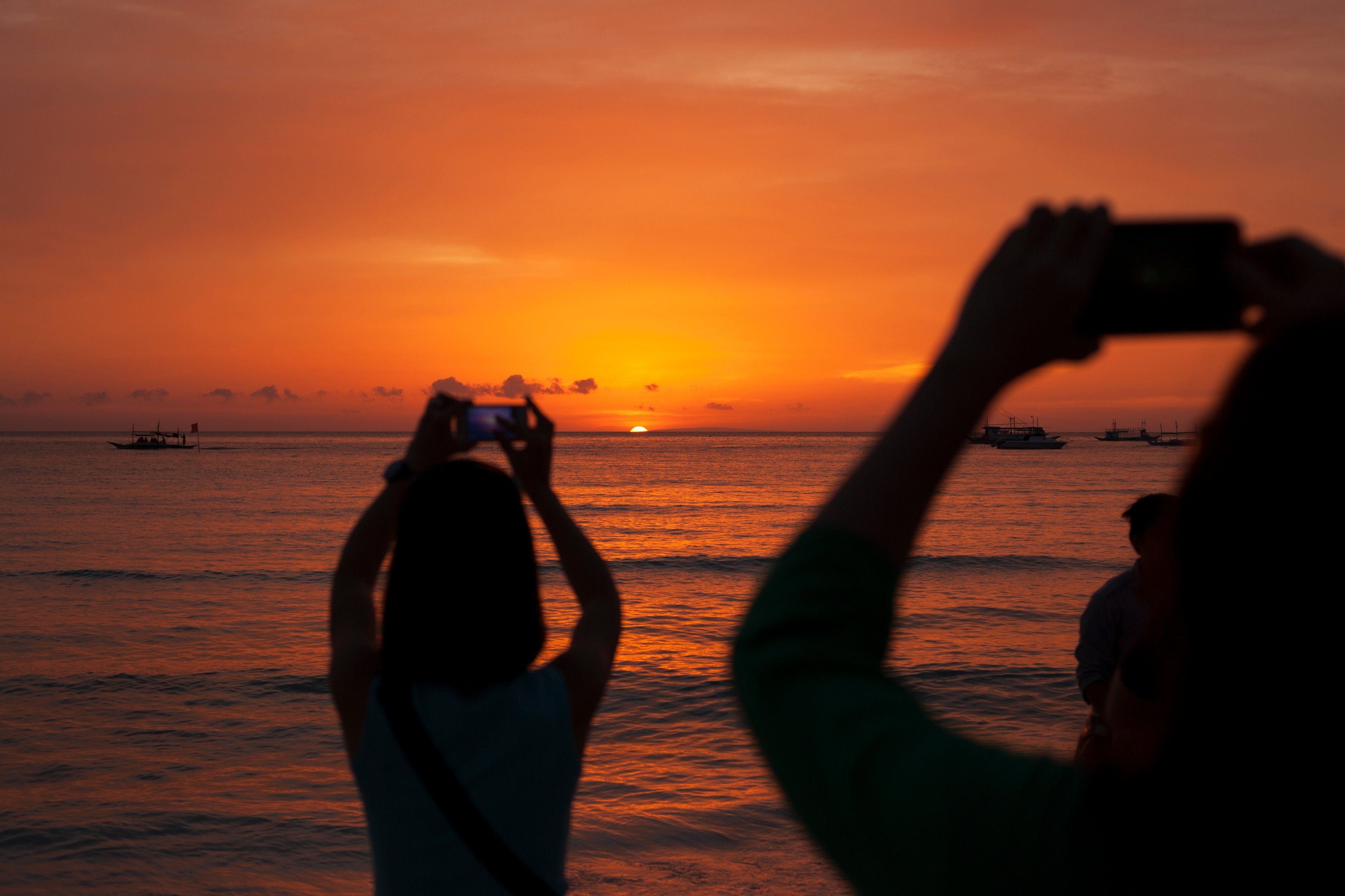 Photo of the Boracay sunset with bystanders taking picture using their phones