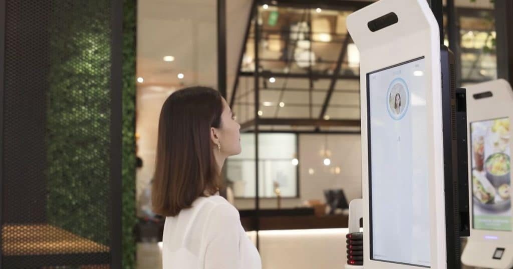 Person using facial recognition software to pay for meal at KFC kiosk