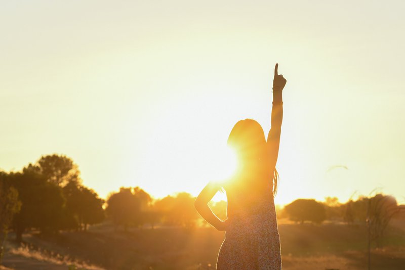 silhouette of a girl pointing up