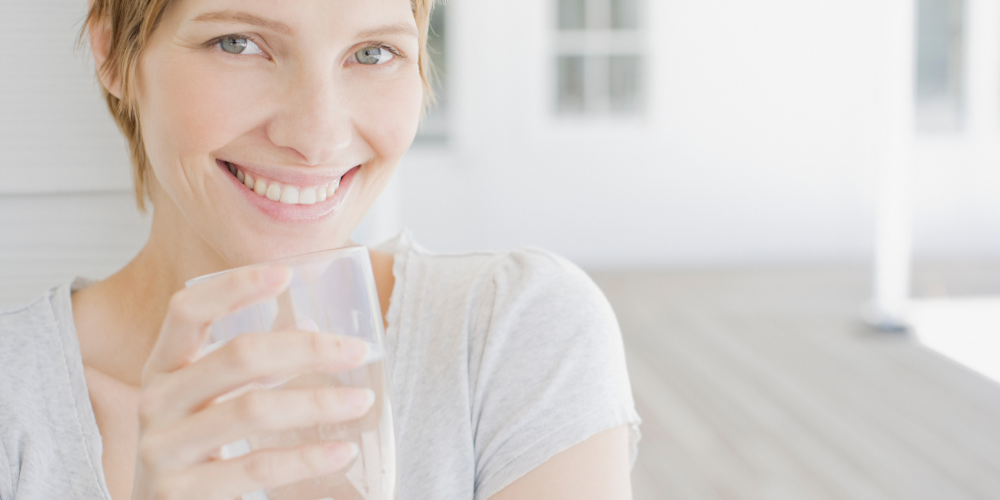 A Woman Holding A Glass Of Water