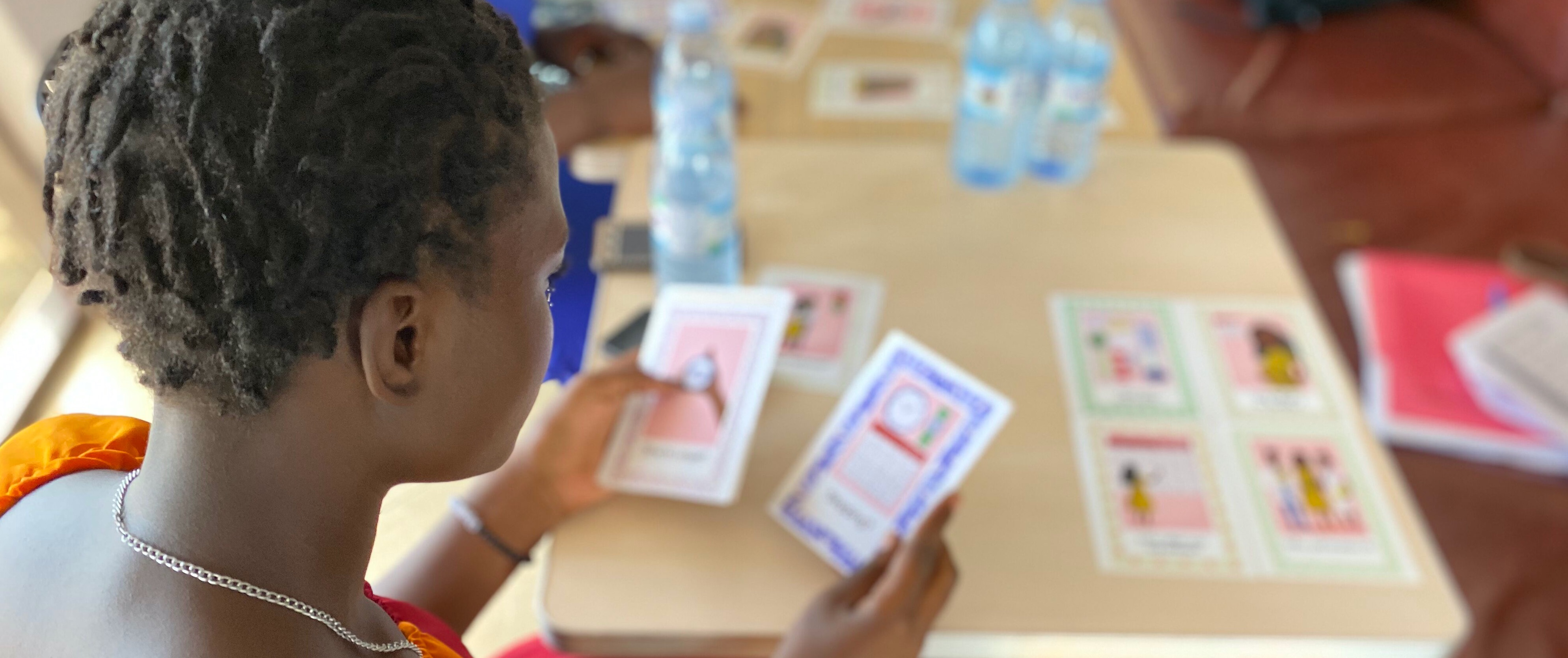 View from behind a girl's head as she holds two cards blurred out