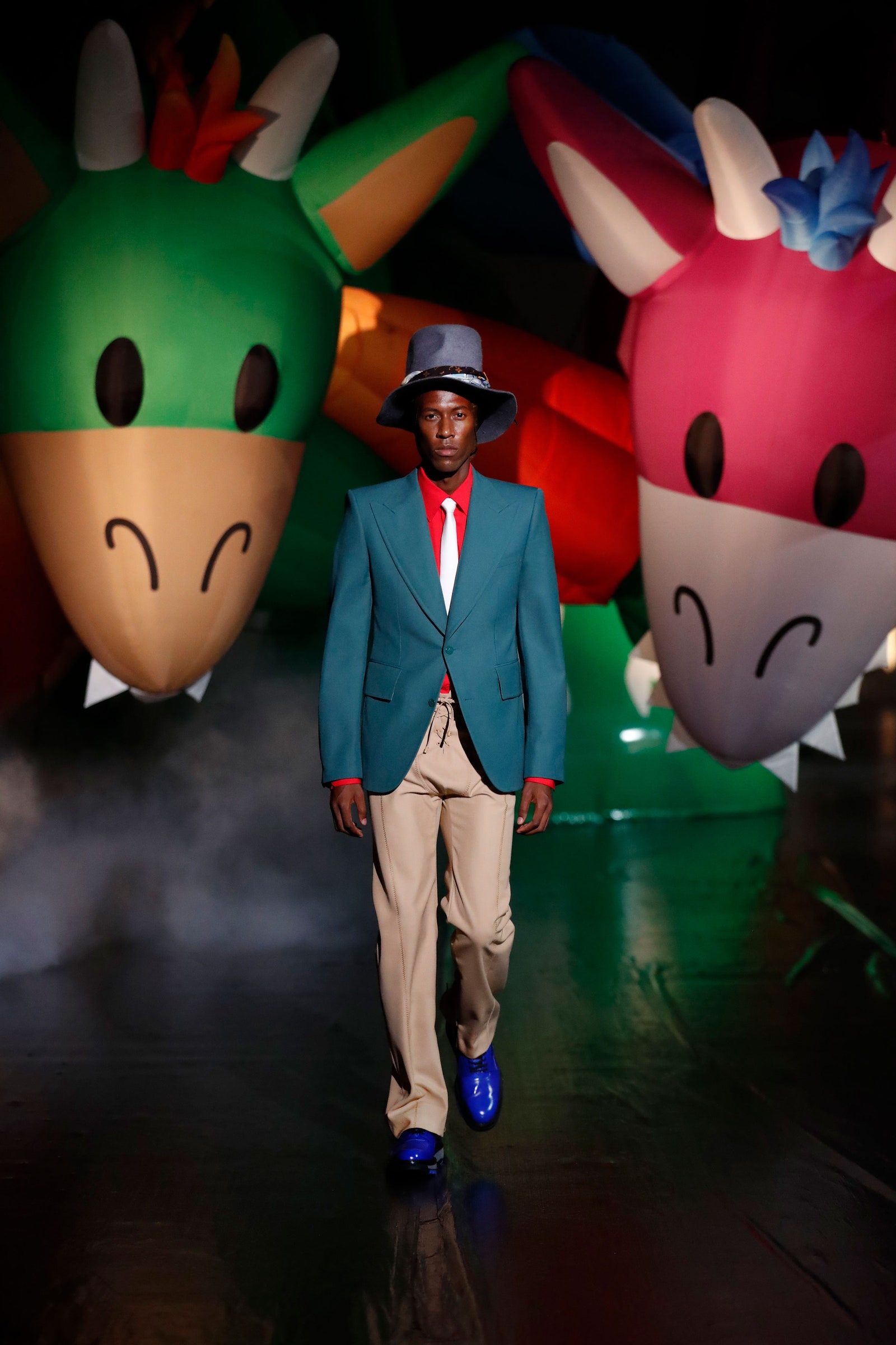 Image may contain Clothing Apparel Suit Coat Overcoat Human Person Hat Shoe Footwear Sleeve and Long Sleeve