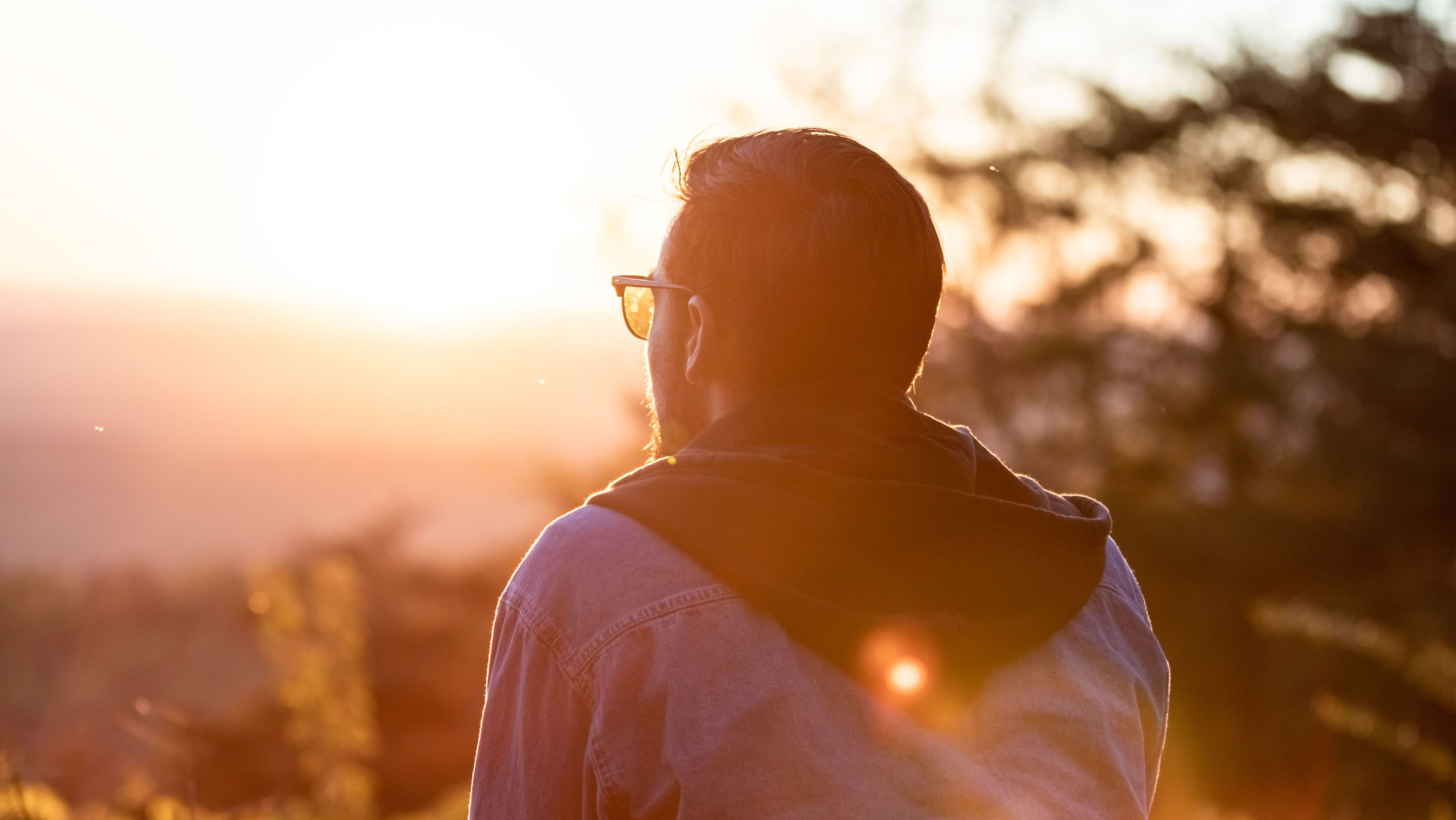 man sitting in a sunny forest reflecting on the positive impacts of cybersecurity bootcamp