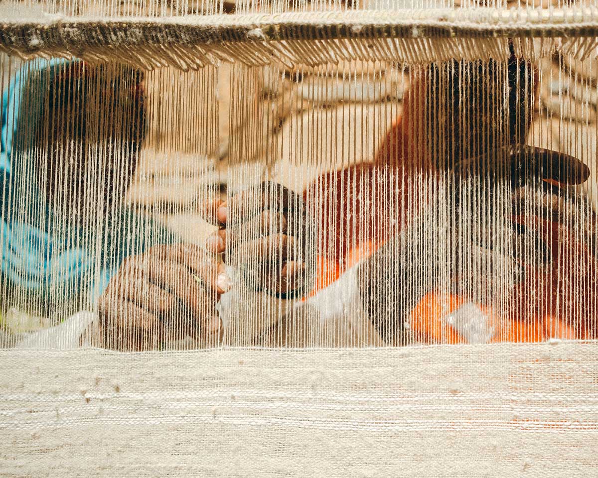 Two weavers from the Anti Atlas weave a wool fabric with some woven cotton symbols.
