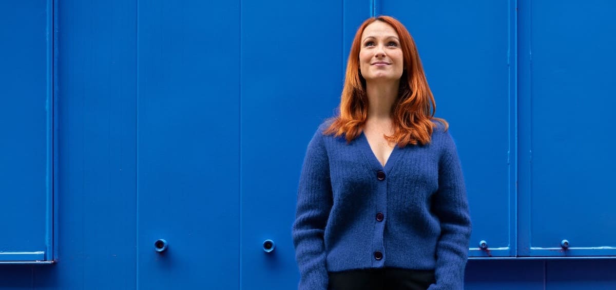 Woman looking up into the sky with blue background