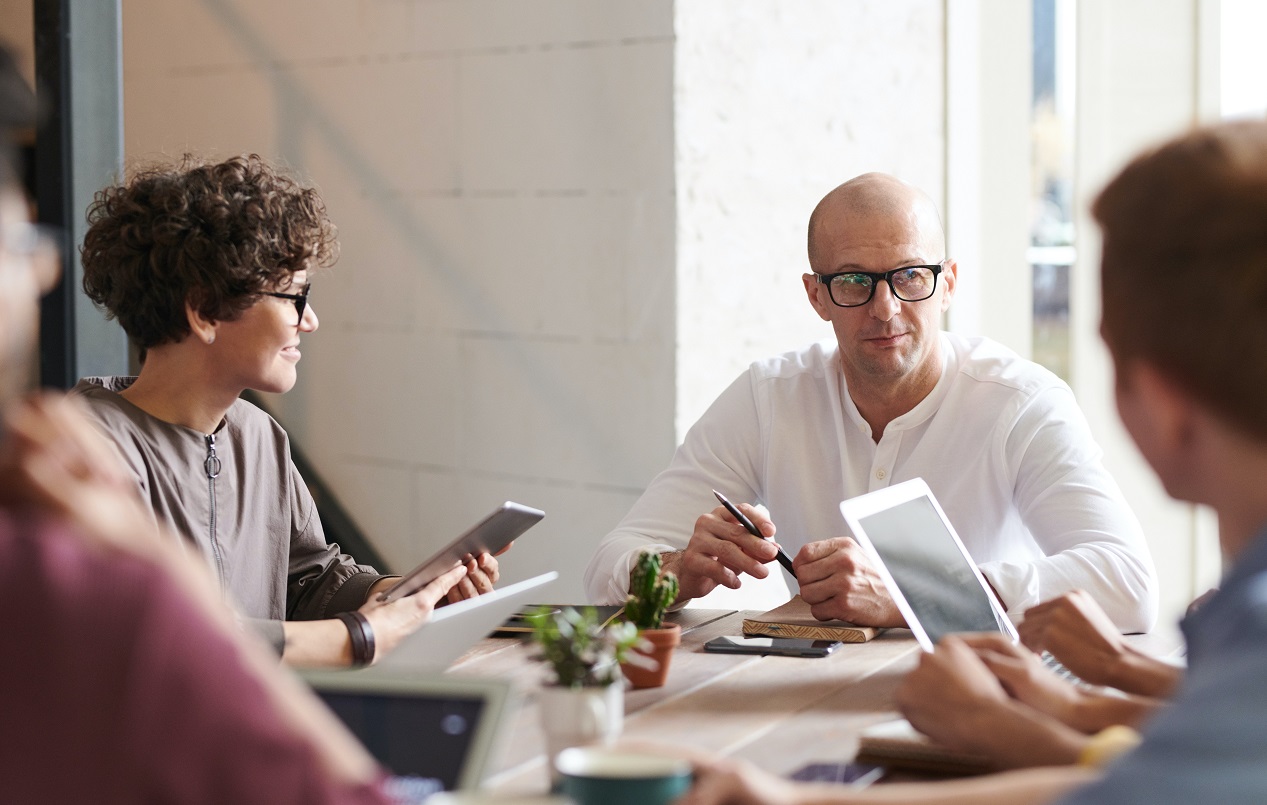 Some executives sitting on a table and discussing 5 cs of communication
