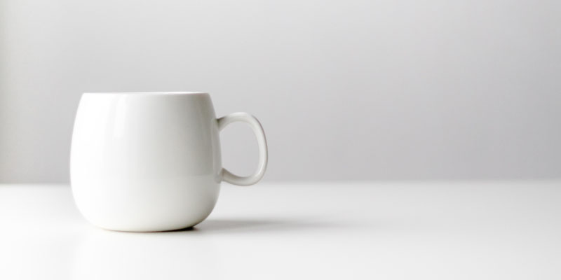 Tasse blanche sur fond gris