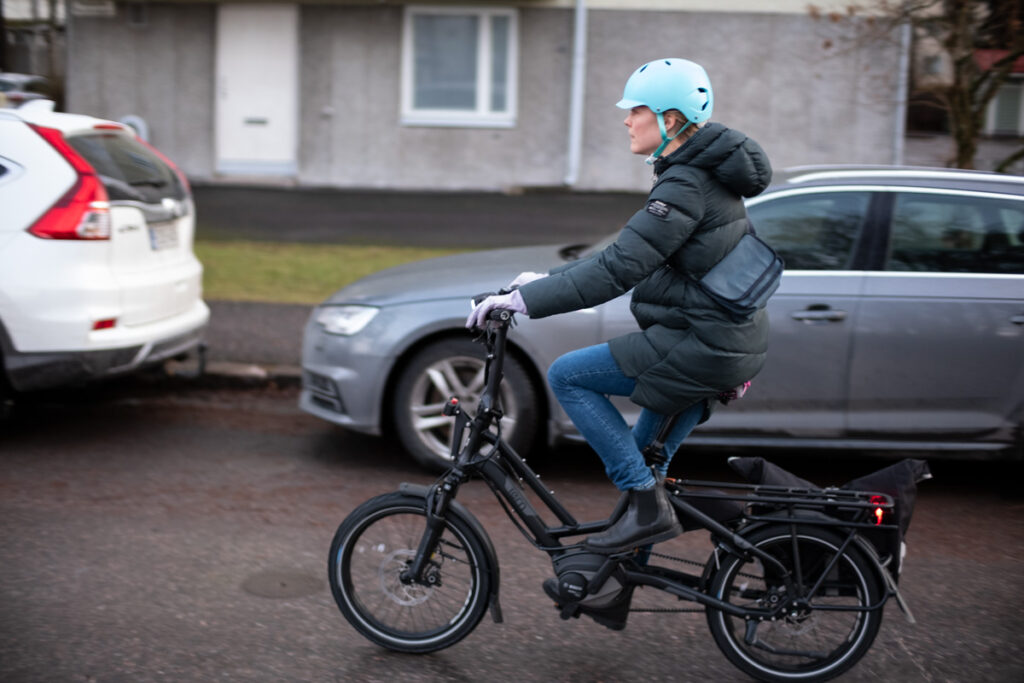 woman in winter coat riding a black Tern HSD