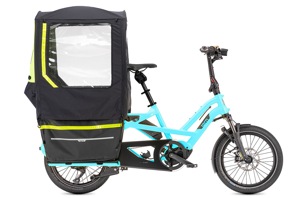 A blue Tern GSD electric cargo bike with a storm fort accessory