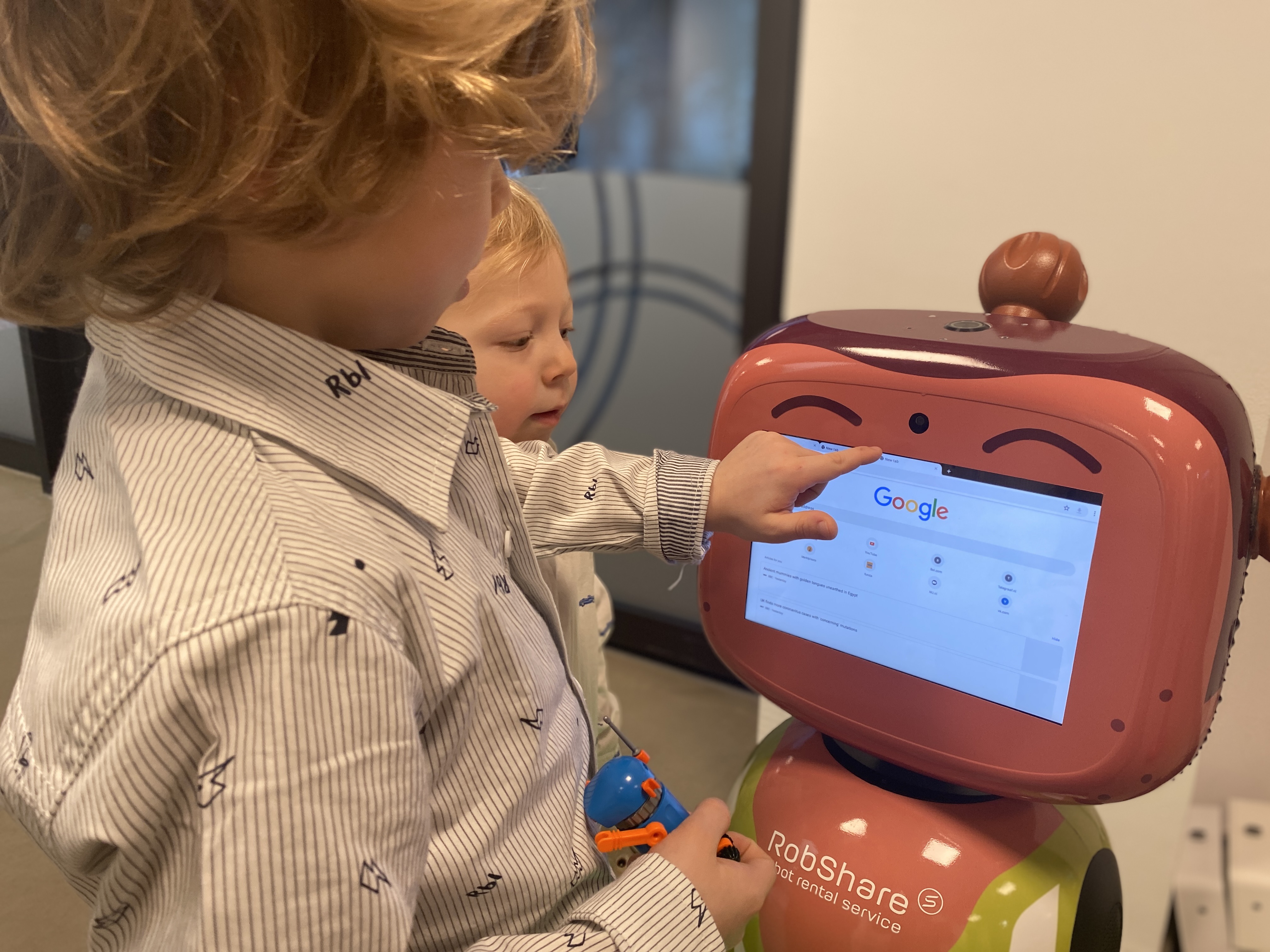 a children is toung the tablet, which is the head of a roboter