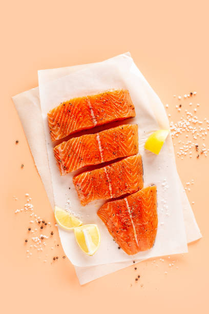 Salmon fillet Slices of fresh salmon with spices on parchment paper salmon stock pictures, royalty-free photos & images