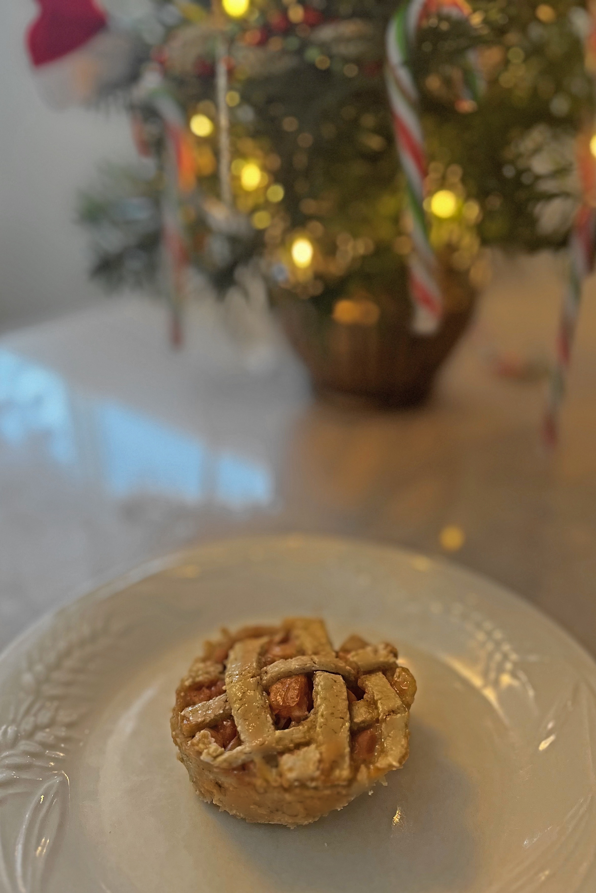 Mini apple pie in front of blurred Christmas background 