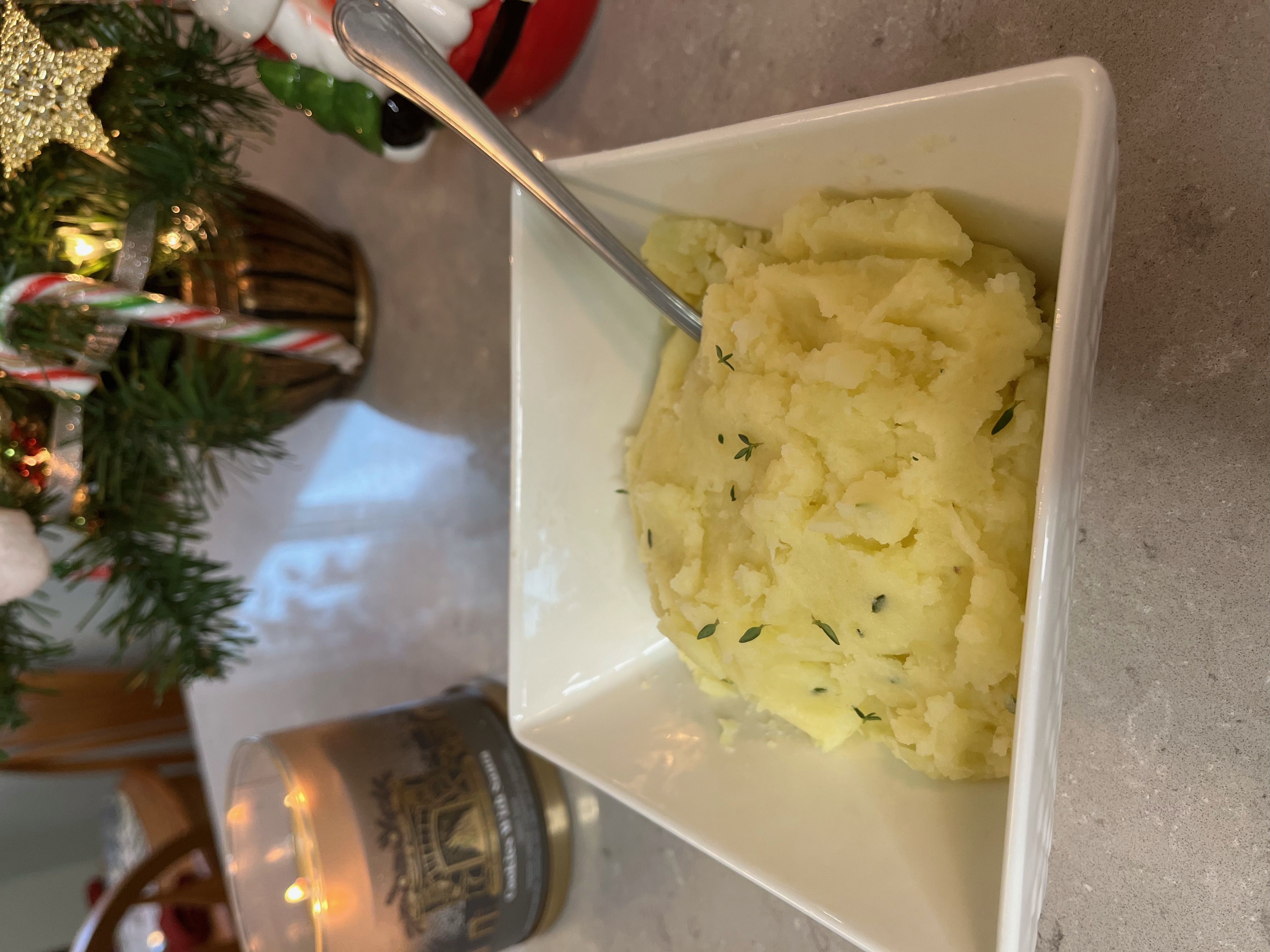 mashed potatoes in a bowl in front of blurred Christmas background 