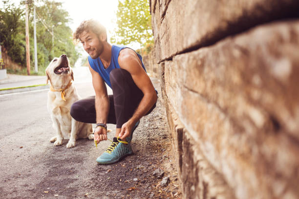 Jogging with my best friend Young man jogging with his dog dog run stock pictures, royalty-free photos & images