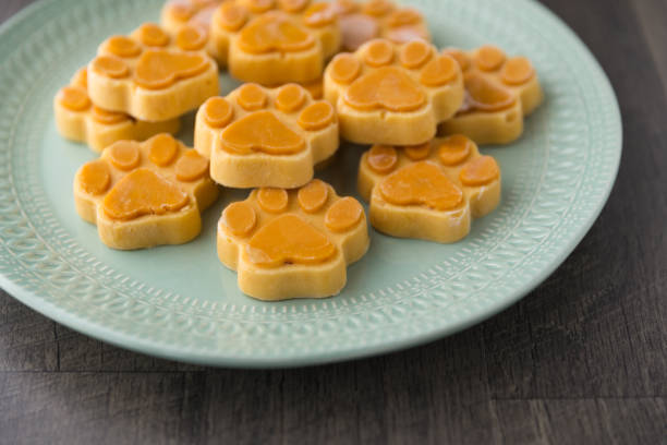 Paw shaped frozen dog treats Paw shaped frozen dog treats on a green plate dog fozen treats stock pictures, royalty-free photos & images
